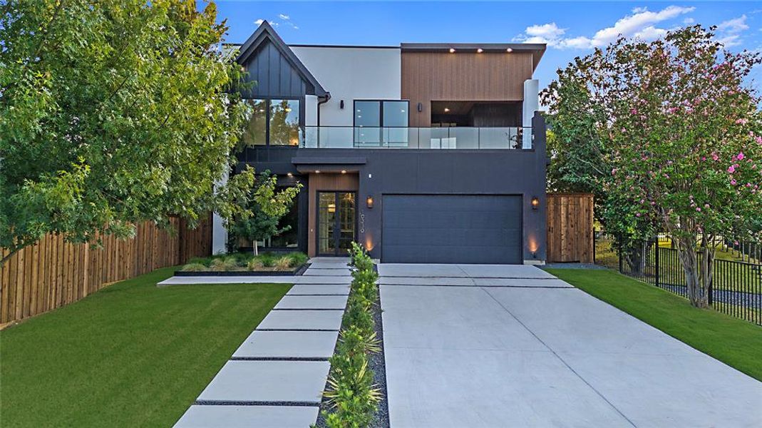 Contemporary home with a balcony, driveway, a garage, and stucco siding Contemporary home with a balcony, driveway, a garage, and stucco siding