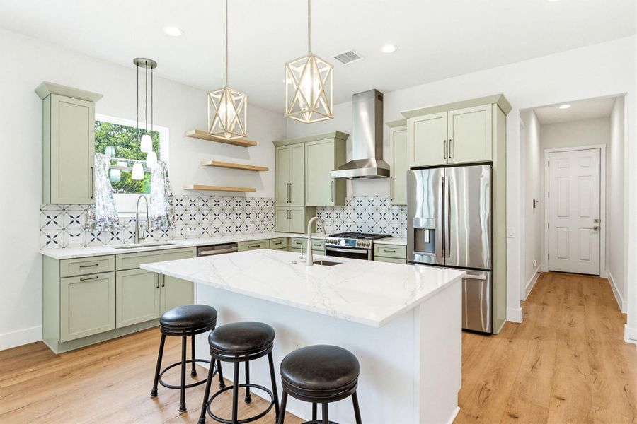 A pristine kitchen features modern appliances and a spacious island, ideal for entertaining.