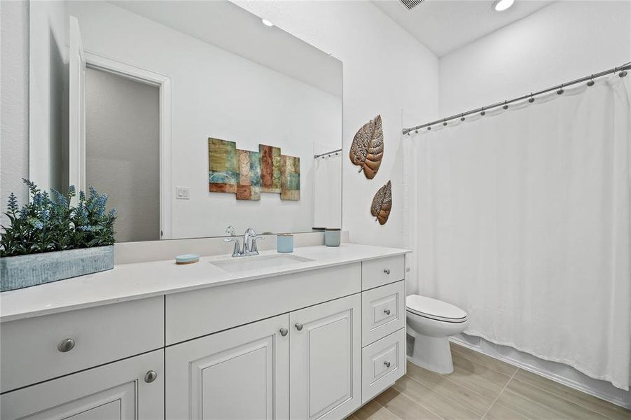 SECONDARY BATH FEATURES SHOWER AND TUB COMBINATION WITH TILE SURROUND. J KRAFT CABINETRY. QUARTZ COUNTERTOPS WITH 4" BACKSPLASH IN THE BATHROOMS. DESIGNER FIXTURES AND FAUCETS. WATER-SAVING ELONGATED COMMODES.