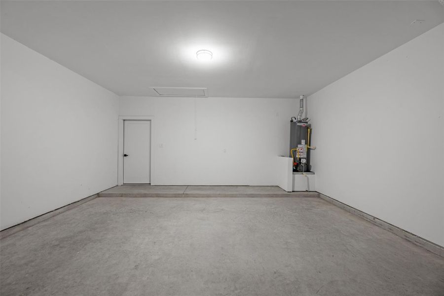 Spacious, clean garage with concrete floors, bright lighting, and a water heater installed in the corner. It is well-maintained and offers ample room for parking and storage. Spacious, clean garage with concrete floors, bright lighting, and a water heater installed in the corner. It is well-maintained and offers ample room for parking and storage.