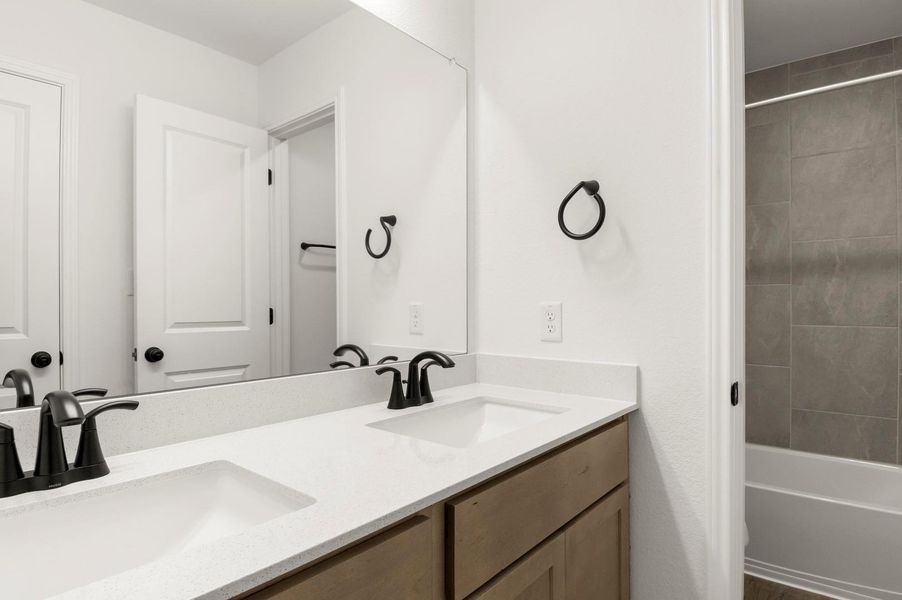 Full bathroom with double vanity and tub / shower combination