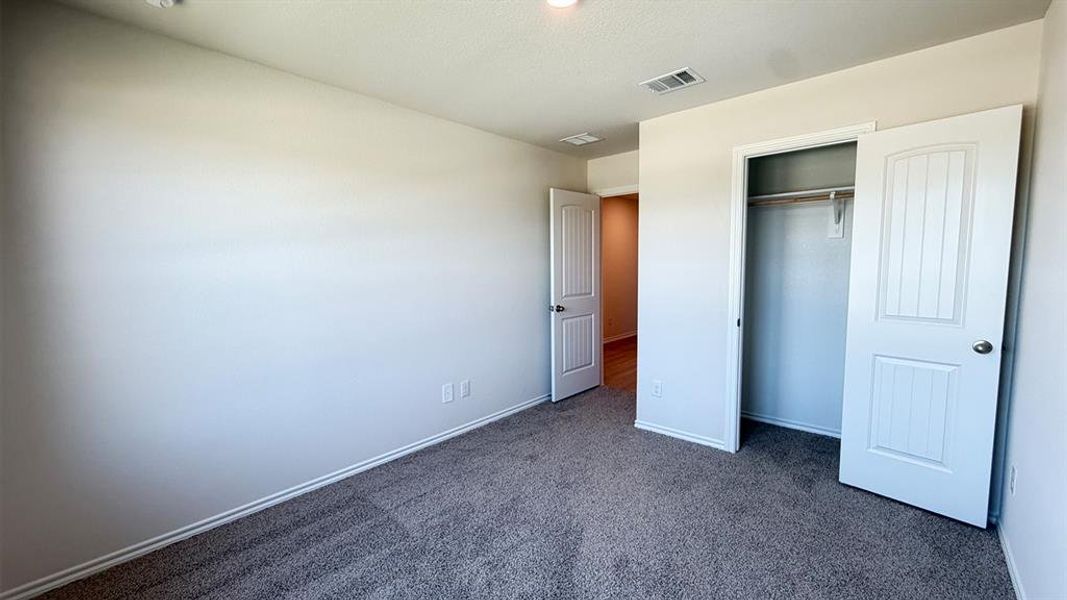 Carpeted room featuring light-colored walls, white trim, and a ceiling light fixture