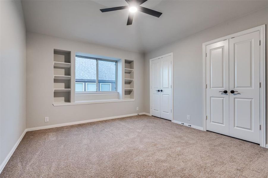 Unfurnished bedroom featuring carpet, two closets, and a ceiling fan Unfurnished bedroom featuring carpet, two closets, and a ceiling fan
