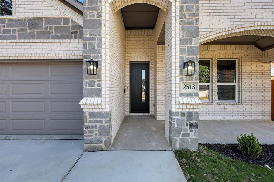 Property entrance with brick siding and an attached garage Property entrance with brick siding and an attached garage