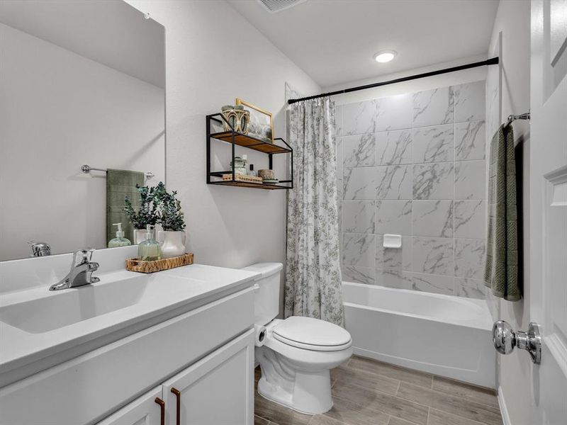 Well-appointed large full bath features modern hardware, tile shower surround and added lighting in the shower.