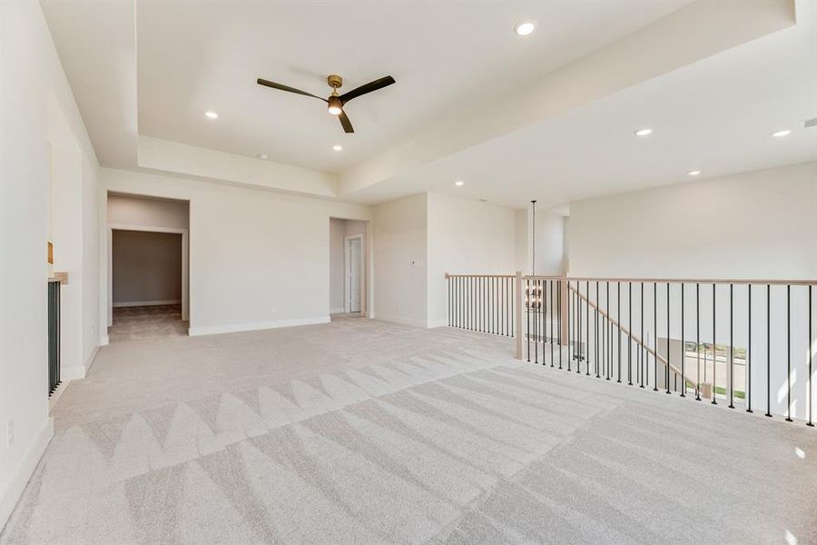 Empty room featuring light colored carpet, a raised ceiling, recessed lighting, and ceiling fan Empty room featuring light colored carpet, a raised ceiling, recessed lighting, and ceiling fan