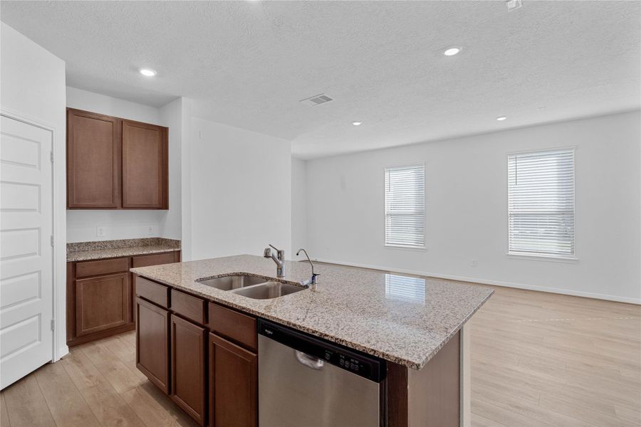Additional view from the kitchen island! The island comes with an added breakfast bar to enhance your seating space and room to spread out and yet stay connected!