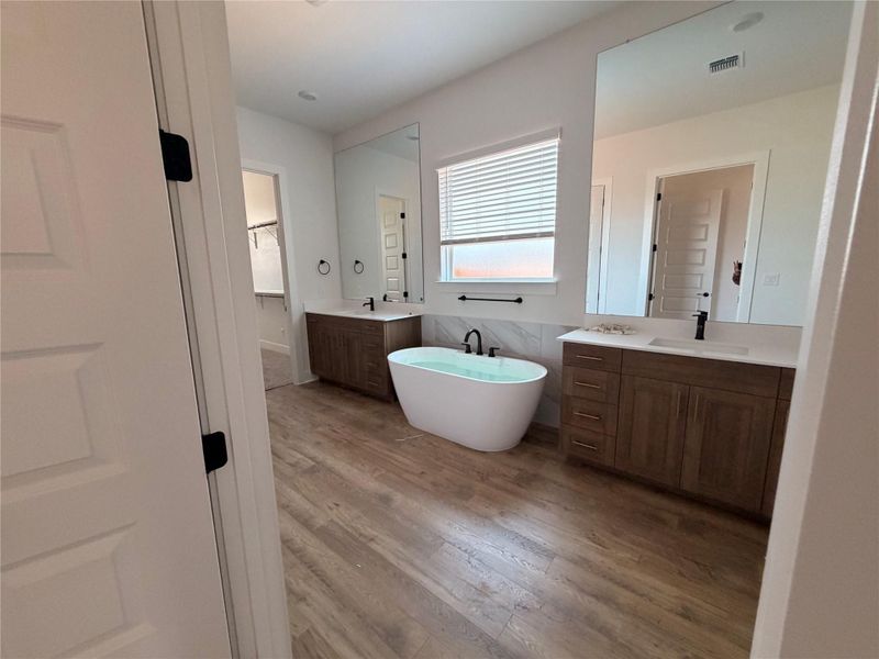 Luxurious soaking tub and dual vanities define this elegant, well-lit bathroom. Luxurious soaking tub and dual vanities define this elegant, well-lit bathroom.