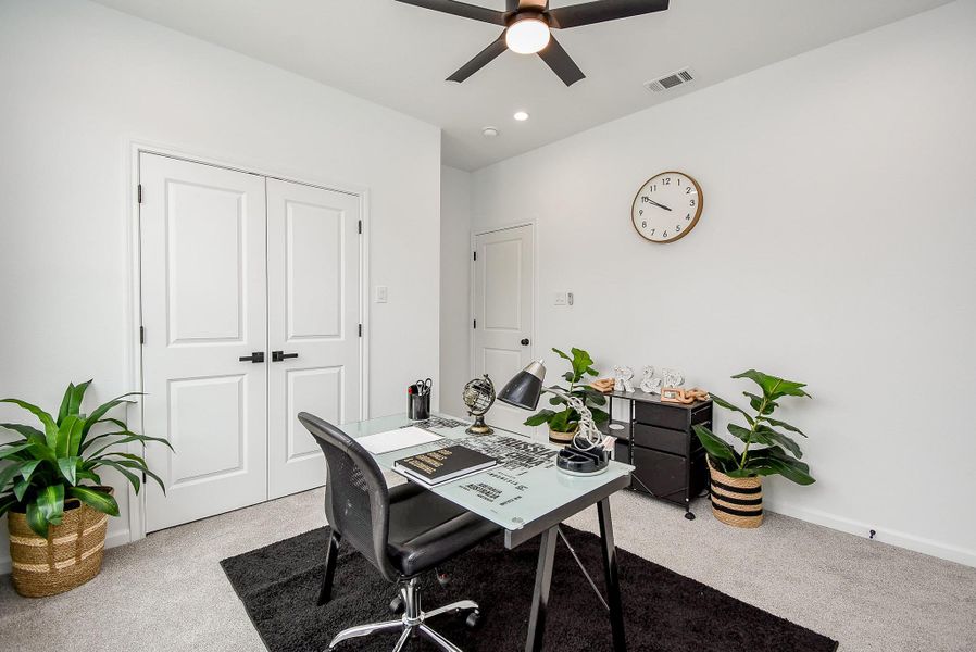 This inviting front room is beautifully staged as a functional office space.