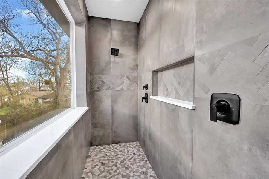 Expansive walk-in shower featuring dual shower heads, a ceiling rain shower, and designer tile finishes.