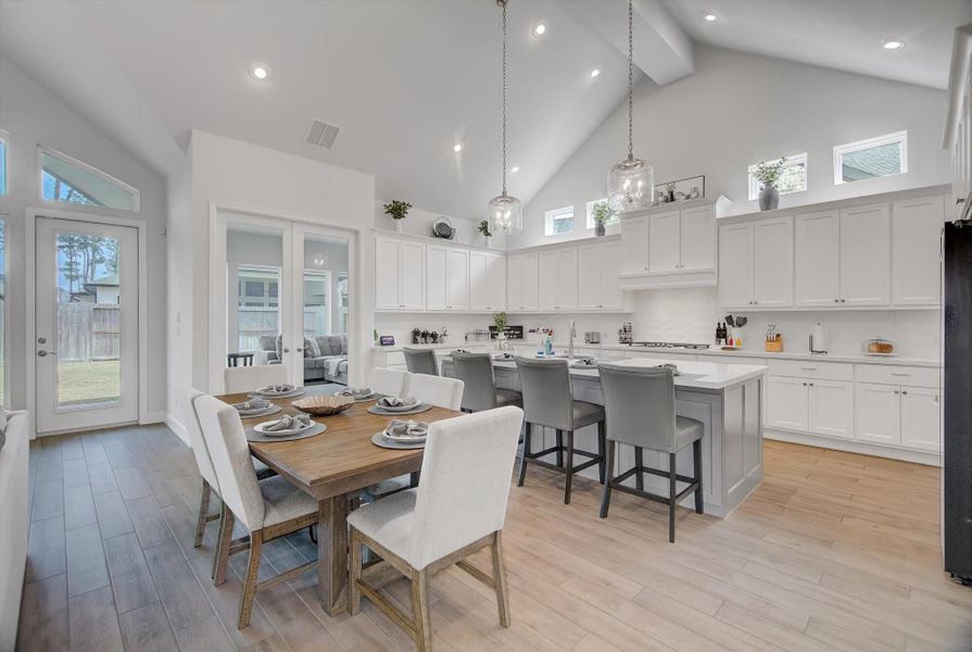 The dining and kitchen combo opens seamlessly into the home’s game room, accessed through a set of elegant French doors that extend the entertaining space and create an easy, open flow.