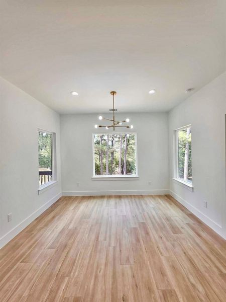 Unfurnished dining area with light wood-style flooring, a chandelier, and recessed lighting