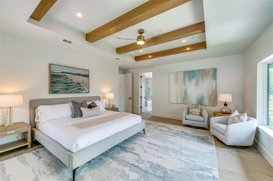 Bedroom with ceiling fan, a raised ceiling, light hardwood / wood-style floors, and beam ceiling