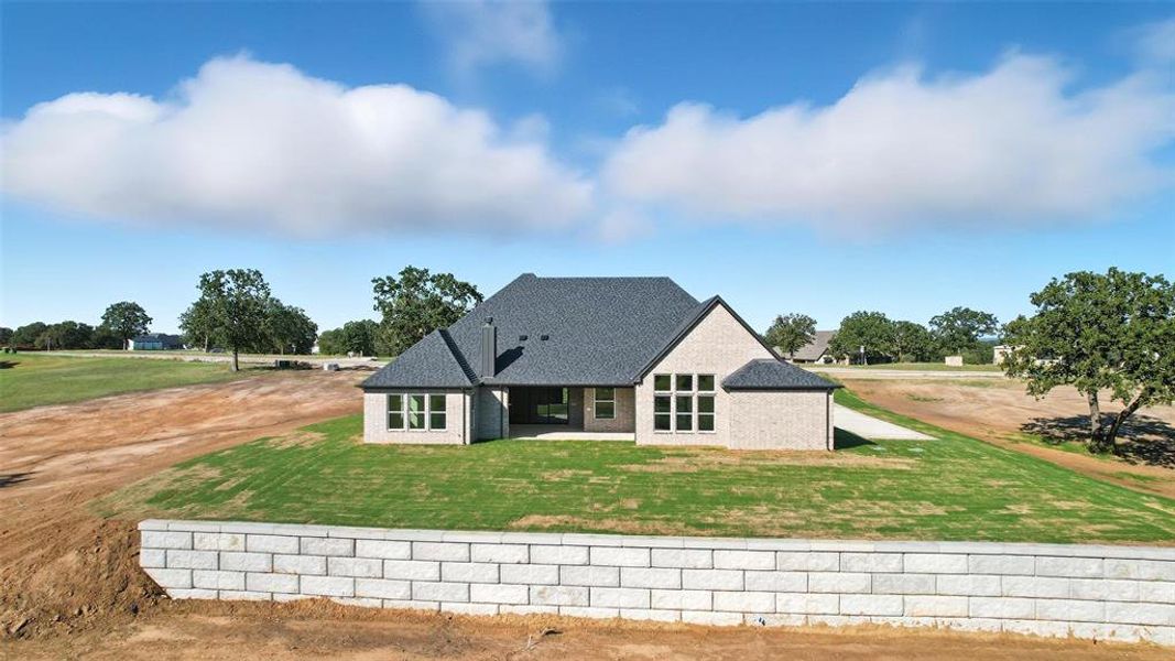 Rear view of house with a patio area, a yard, brick siding, and a shingled roof Rear view of house with a patio area, a yard, brick siding, and a shingled roof