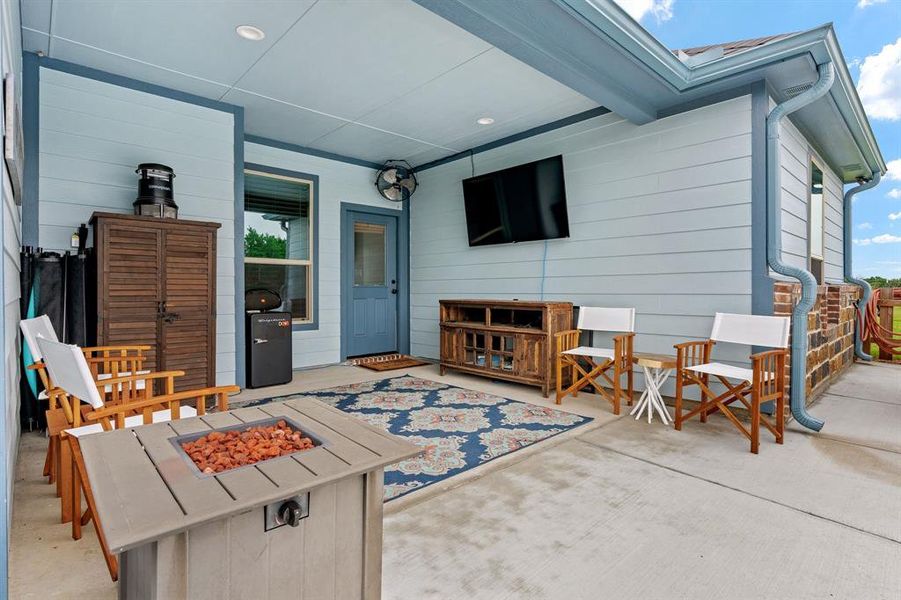 View of patio / terrace with an outdoor fire pit and TV perfect for evening relaxation.