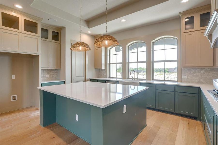 Kitchen with tasteful backsplash, a center island, recessed lighting, and a sink