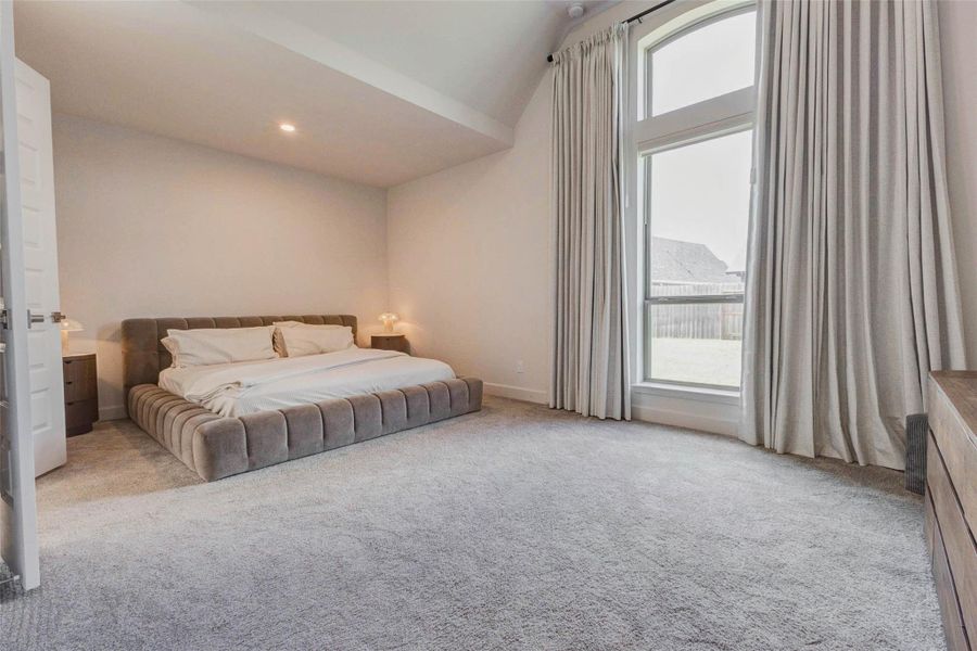 Primary bedroom features high ceilings, and a large window with elegant curtains, offering ample natural light and a serene view. The neutral color scheme and soft carpeting add to the room's cozy and inviting atmosphere. Primary bedroom features high ceilings, and a large window with elegant curtains, offering ample natural light and a serene view. The neutral color scheme and soft carpeting add to the room's cozy and inviting atmosphere.