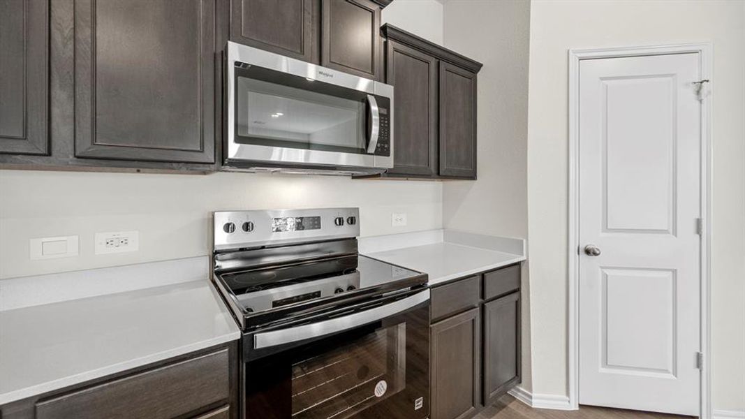 Kitchen featuring stainless steel appliances and dark wood finish cabinetry