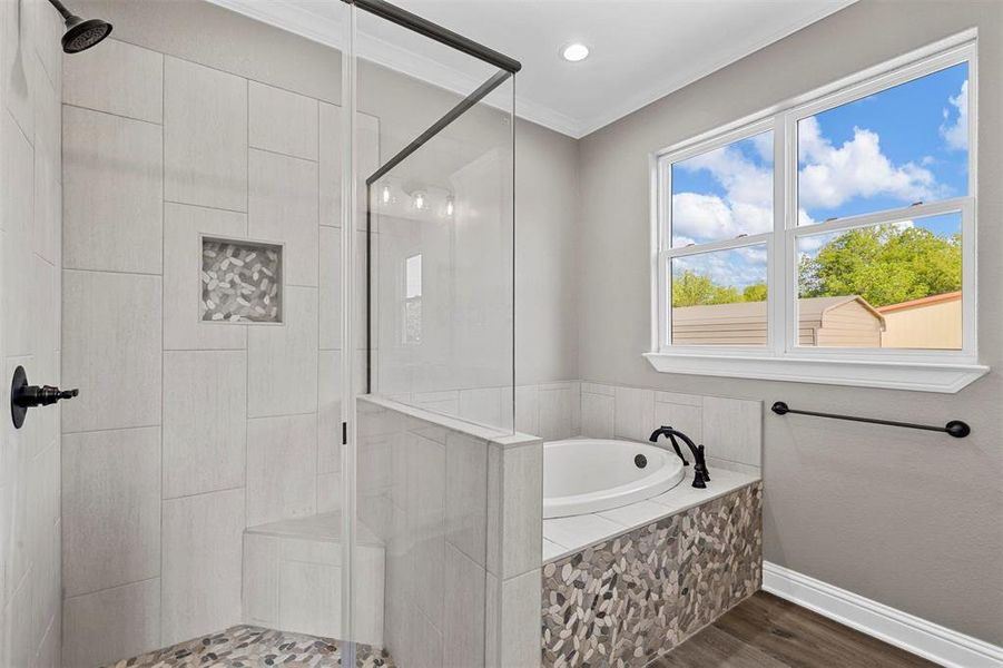 Bathroom with crown molding, hardwood / wood-style floors, and shower with separate bathtub