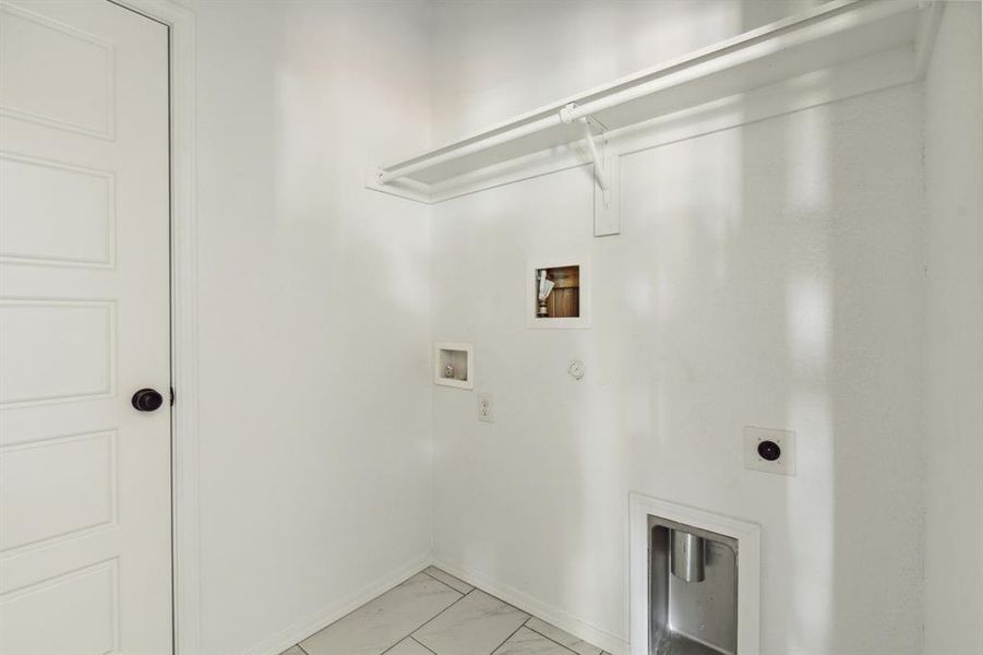 Washroom with washer hookup, electric dryer hookup, light tile patterned floors, and hookup for a gas dryer