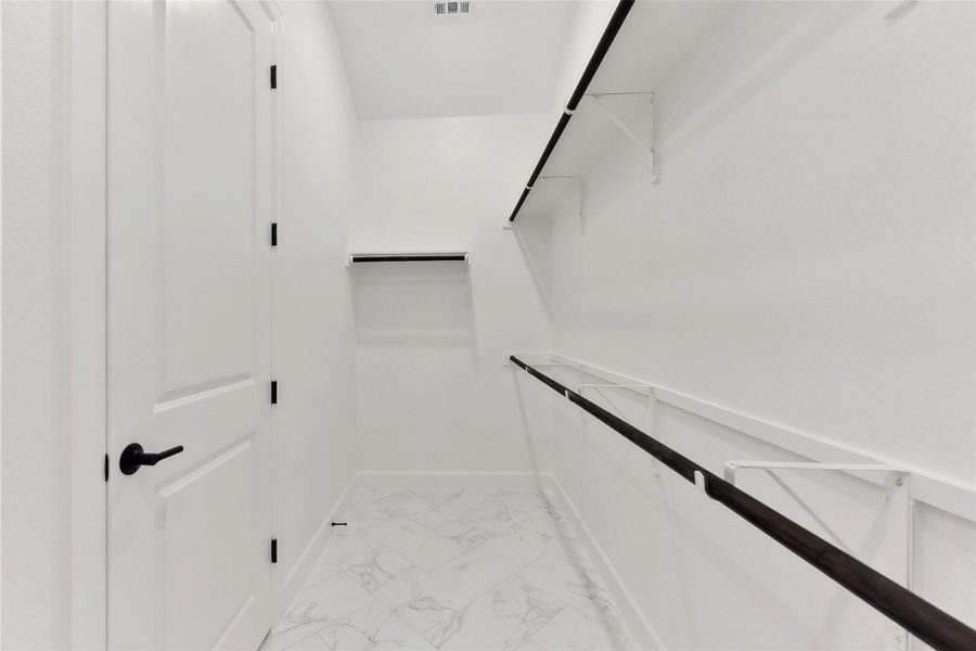 Spacious closet featuring light marble finish floors Spacious closet featuring light marble finish floors
