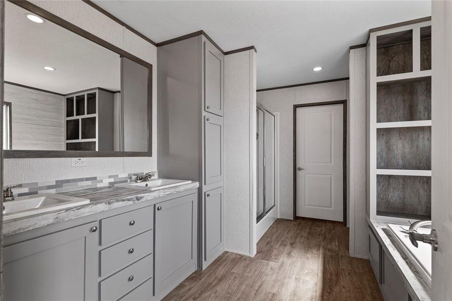 Bathroom featuring double vanity, a shower stall, light wood-style flooring, recessed lighting, and a garden tub