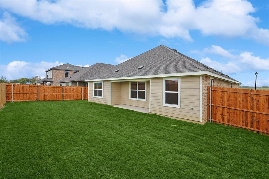 Rear view of house with a patio area and a lawn