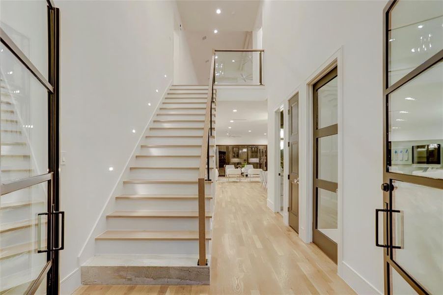 FOYER:  Dramatic two story space with elegant marbled first step and glass balustrade with stair lighting accents.  Touch one of the paneled doors under the staircase and you’ll find perfect place for holiday storage or golf clubs.