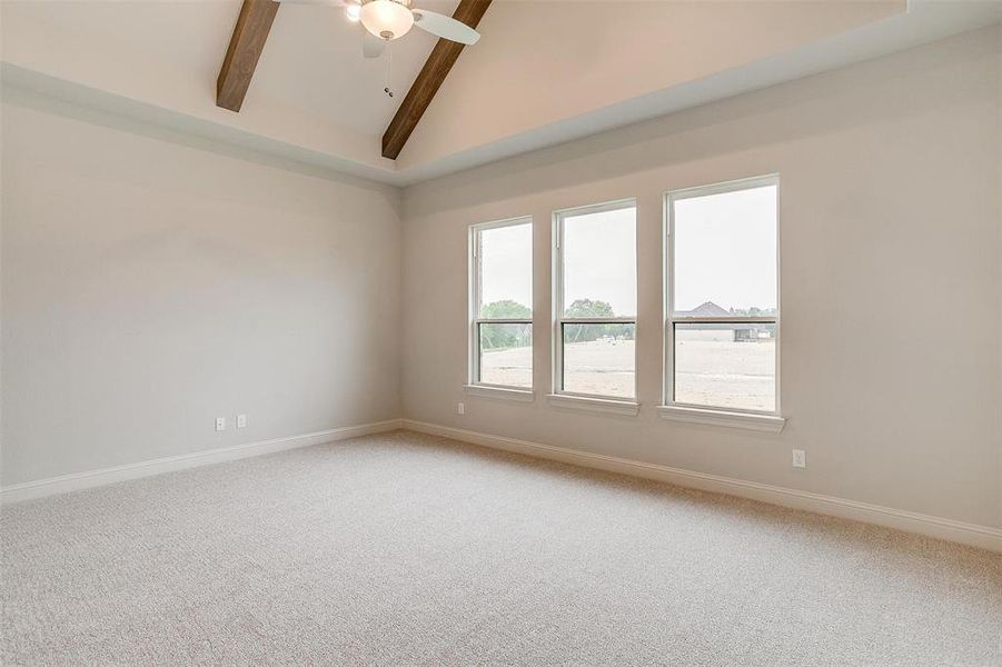 Unfurnished room with lofted ceiling with beams, carpet, and ceiling fan