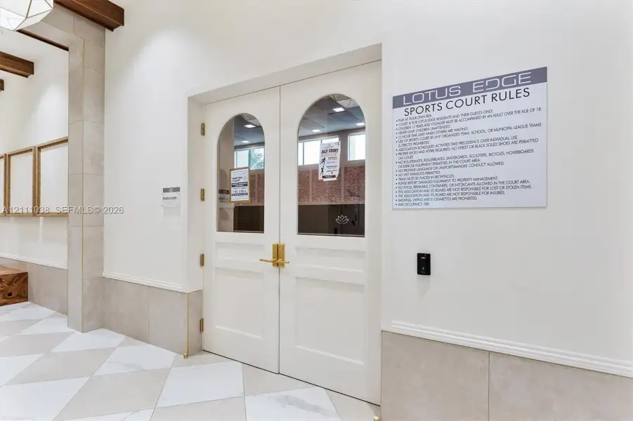 Double doors featuring arched glass panels, brass hardware, and electronic keyless entry