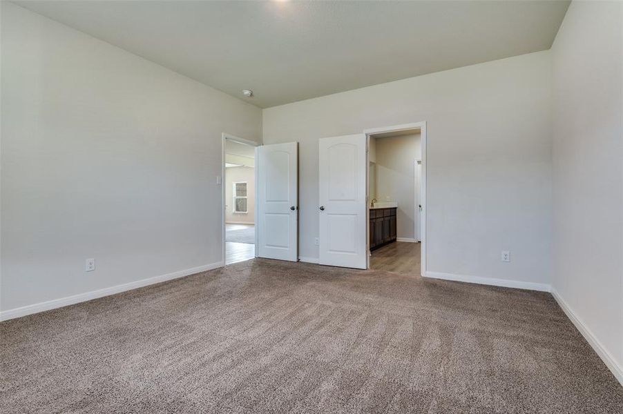 Unfurnished bedroom featuring carpet and connected bathroom