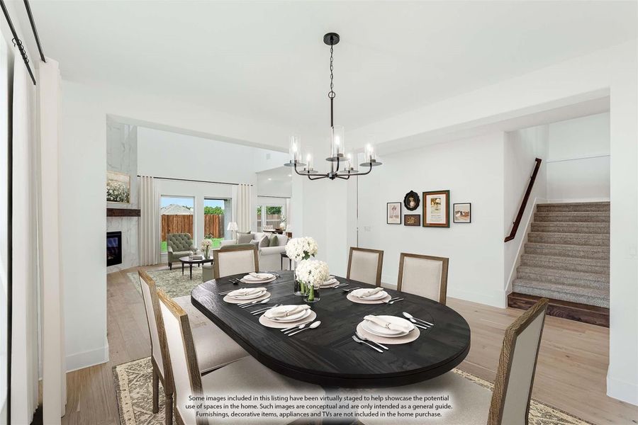 Dining room with dark oval table, six chairs, chandelier, and hardwood floors, open to living room with fireplace. Dining room with dark oval table, six chairs, chandelier, and hardwood floors, open to living room with fireplace.