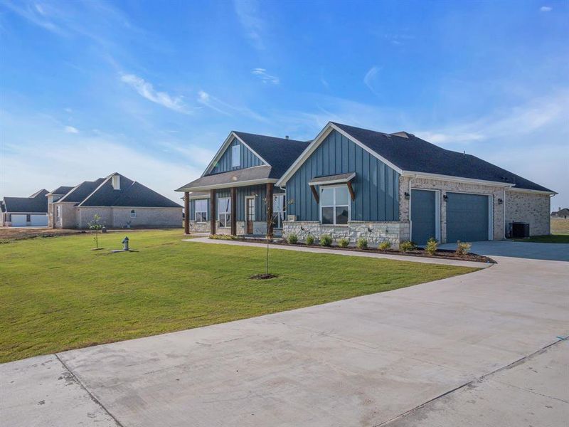 Craftsman inspired home featuring central AC, a porch, a front lawn, and a garage