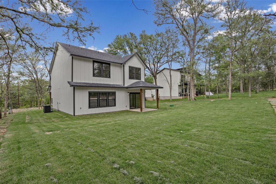 Contemporary two-story exterior with white vertical siding and black trim windows Contemporary two-story exterior with white vertical siding and black trim windows