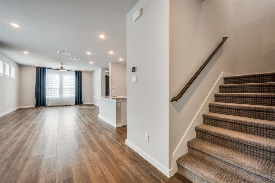 Stairway featuring a ceiling fan, wood finished floors, visible vents, baseboards, and recessed lighting