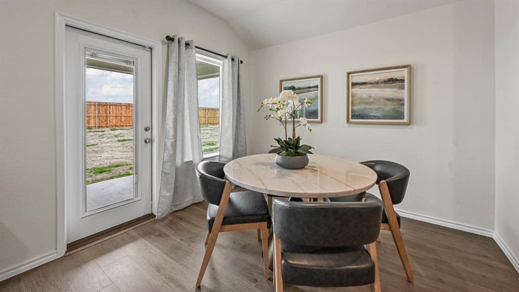 Dining area with lofted ceiling and wood finished floors Dining area with lofted ceiling and wood finished floors