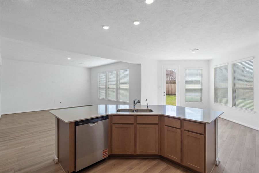 A commanding view from the kitchen to the Great Room, Breakfast nook and outdoor backyard space.