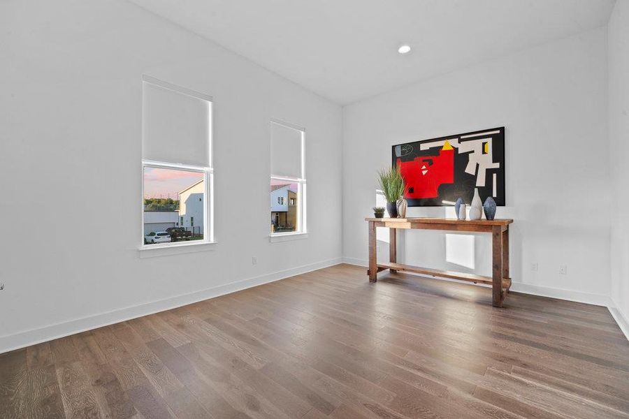 Empty room with dark wood-style flooring and recessed lighting