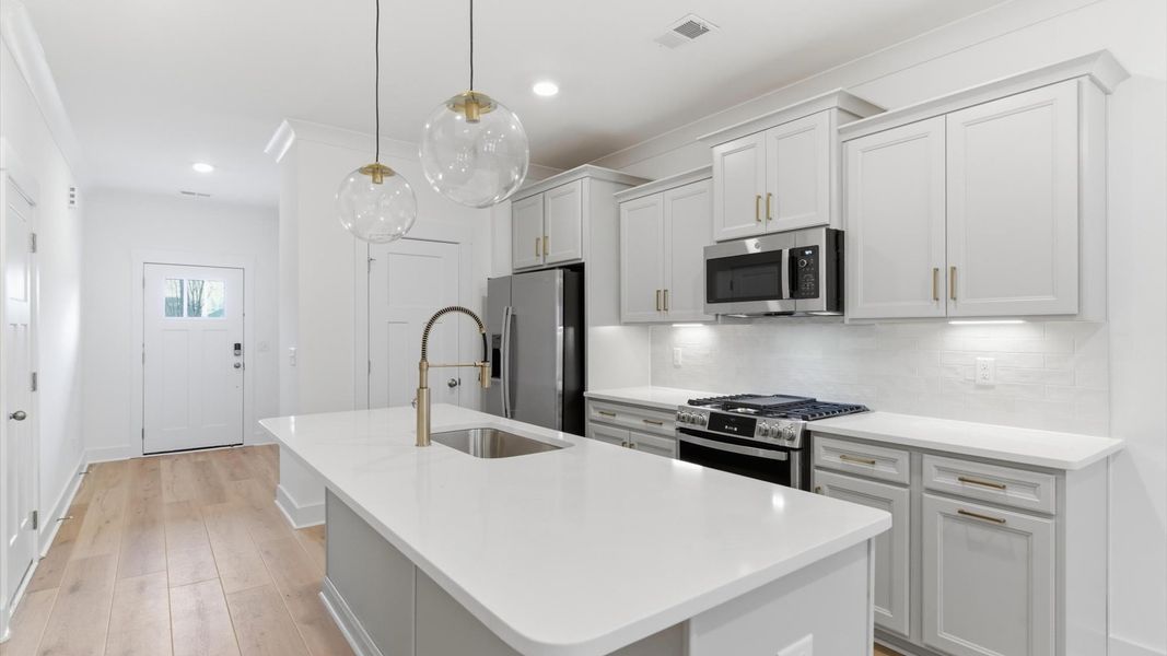 Superior kitchen with quartz countertops, pendant lighting, and a generously sized island