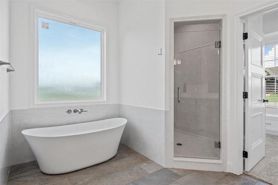 Bathroom featuring a stall shower and a freestanding bath Bathroom featuring a stall shower and a freestanding bath