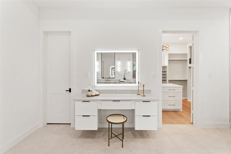 An elegant floating makeup vanity with oversized LED mirror adds another level of luxury to the primary bathroom, offering a private beauty station with perfect lighting for beauty routines. This premium amenity ensures both partners can prepare simultaneously without compromising workspace or lighting quality.