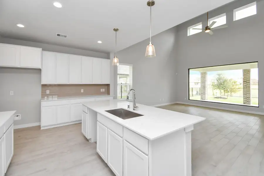 Culinary haven, featuring granite countertops, a tile backsplash, stainless steel appliances (to be installed), and 42” upper cabinets. Sample photo of completed home with similar floor plan. Actual colors and selections may vary. Culinary haven, featuring granite countertops, a tile backsplash, stainless steel appliances (to be installed), and 42” upper cabinets. Sample photo of completed home with similar floor plan. Actual colors and selections may vary.