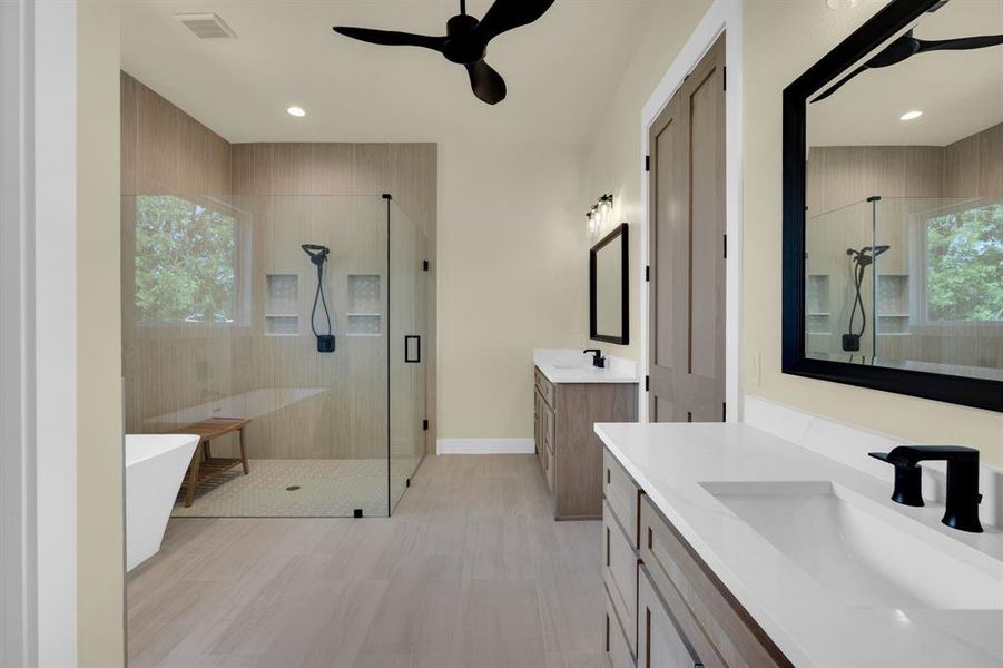 Bathroom featuring ceiling fan, vanity, and plus walk in shower