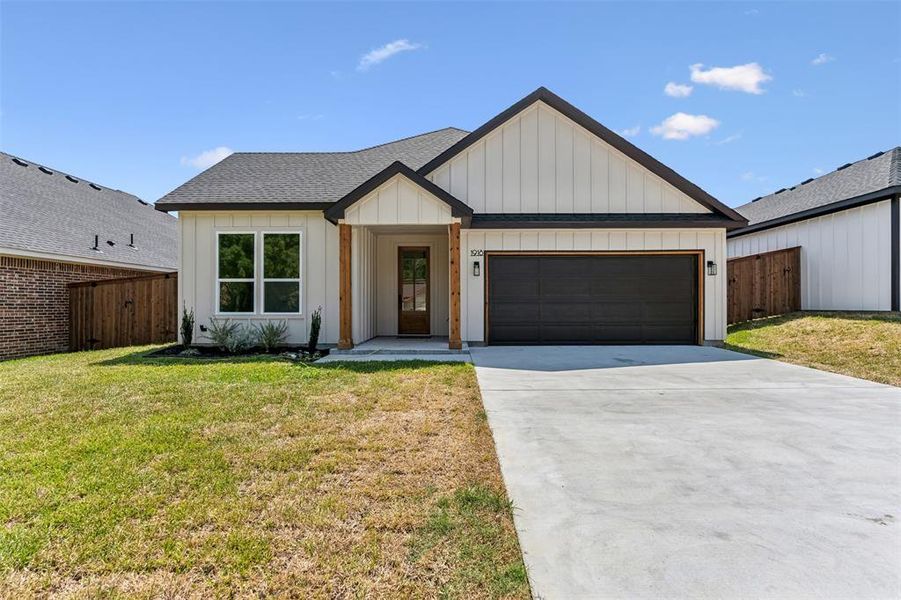 Modern inspired farmhouse with a garage and a front yard