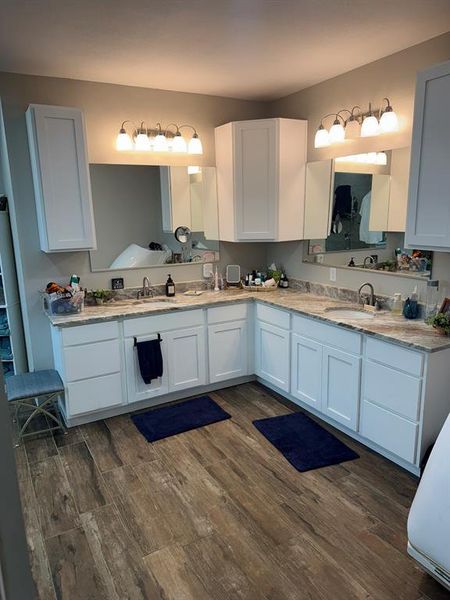 Bathroom with double vanity and dark wood finished floors Bathroom with double vanity and dark wood finished floors