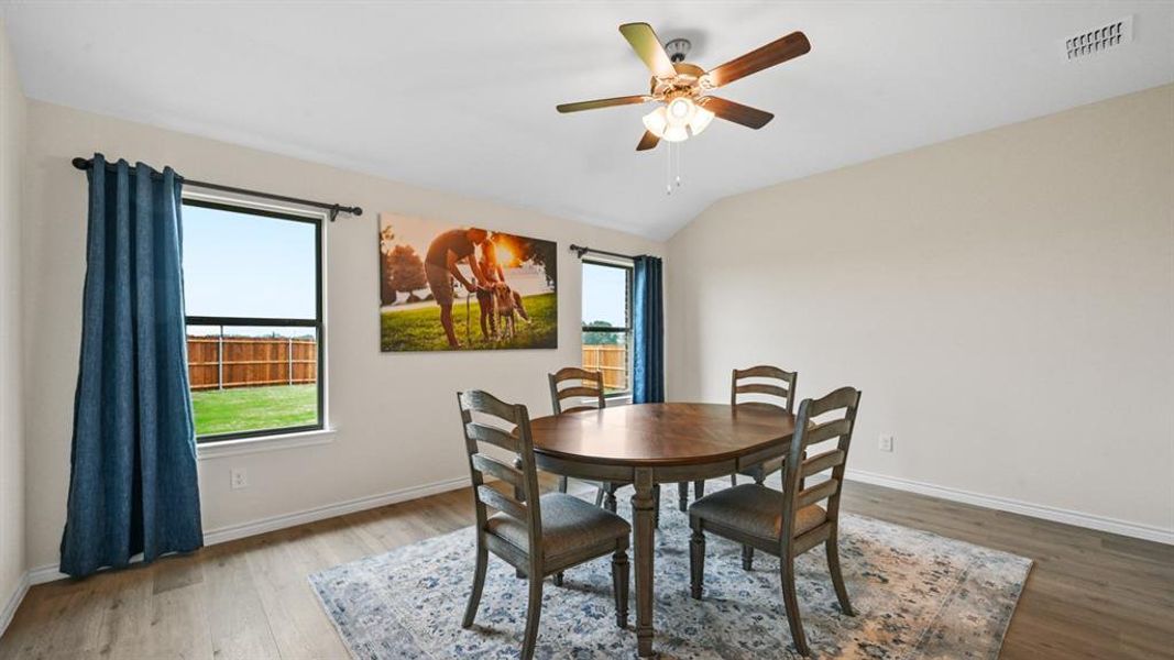 Dining area featuring light wood-style flooring, ceiling fan, and lofted ceiling Dining area featuring light wood-style flooring, ceiling fan, and lofted ceiling
