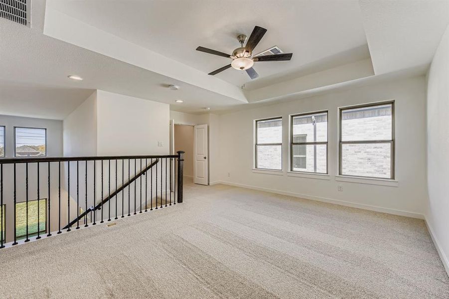 Spare room with healthy amount of natural light, light colored carpet, a raised ceiling, and recessed lighting Spare room with healthy amount of natural light, light colored carpet, a raised ceiling, and recessed lighting