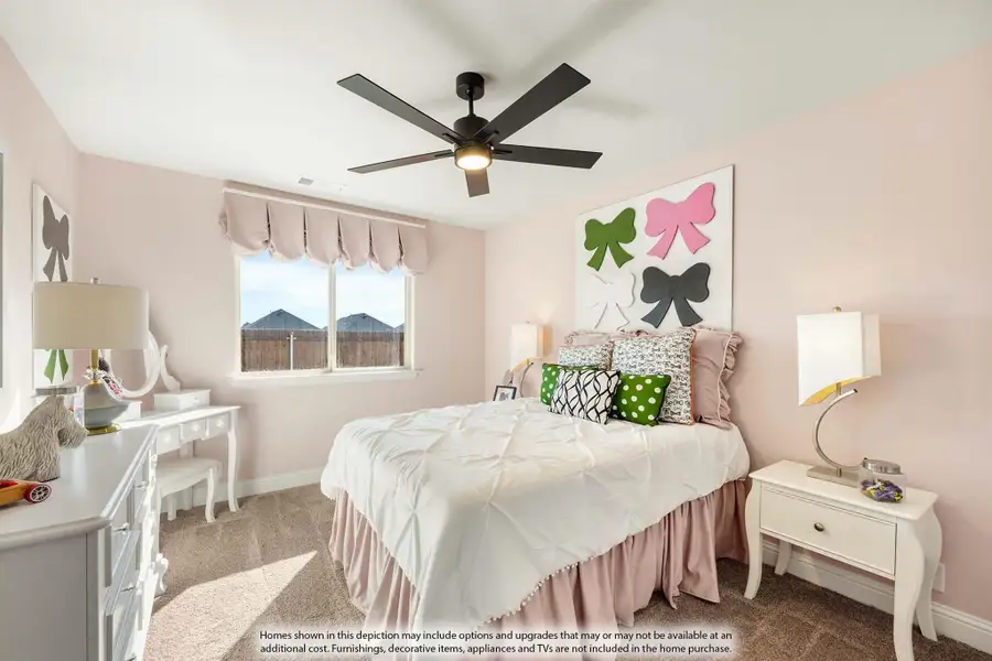 Children's bedroom with pink walls, ceiling fan, bow wall art, and white furniture on carpet