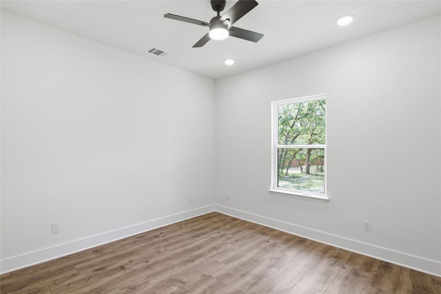 Laminate flooring and recessed lighting define this inviting bedroom, offering views of the natural landscape. Laminate flooring and recessed lighting define this inviting bedroom, offering views of the natural landscape.