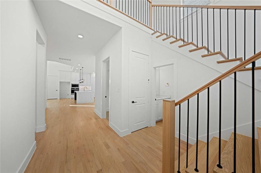 Corridor featuring light wood-style flooring, stairs, and recessed lighting Corridor featuring light wood-style flooring, stairs, and recessed lighting